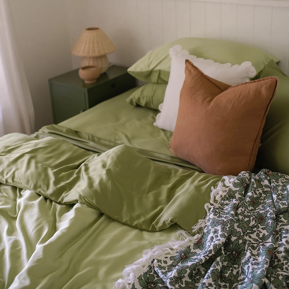 Styled bed featuring the Fern 100% Bamboo Sheet Set with a throw blanket and decorative pillows.