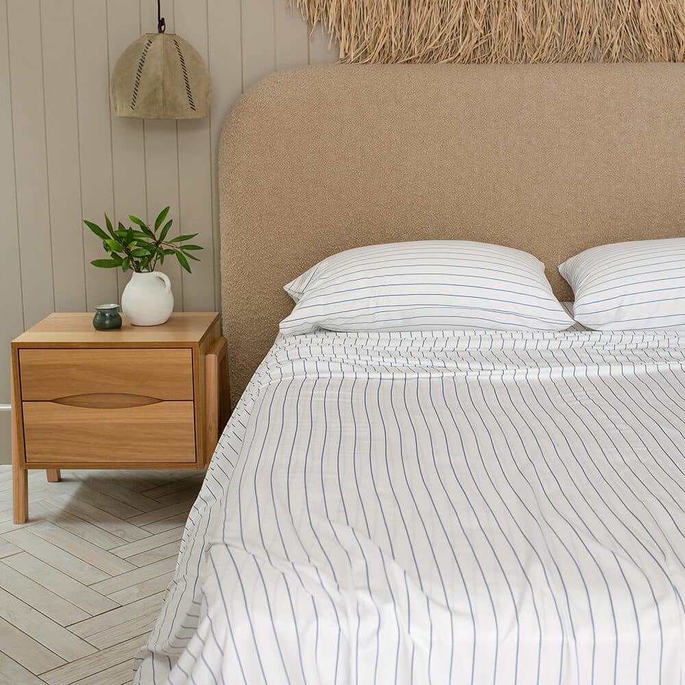 Bamboo Haus Ocean Stripe Sheet Set - 100% bamboo bedding in a soft blue striped design, shown neatly arranged on a bed.